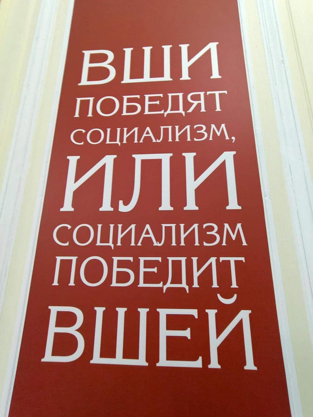Красная вывеска с двойственным лозунгом в Marc Wogau, Россия