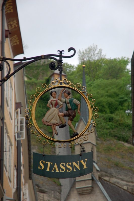 Zalzburg: вывеска 'STASSNY' с фигурками в традиционных костюмах