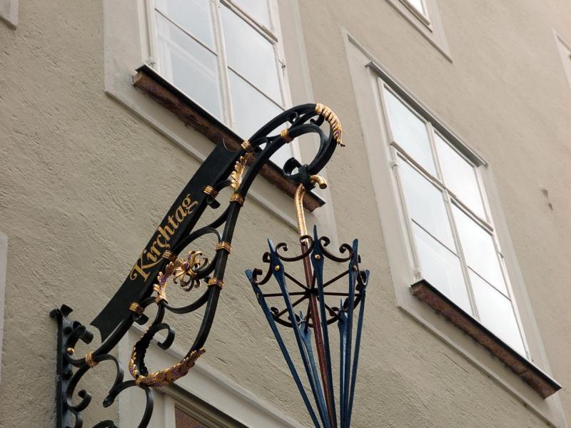 Zalzburg: чёрно-золотой фонарь с зонтом и вывеской «Kirchtag»