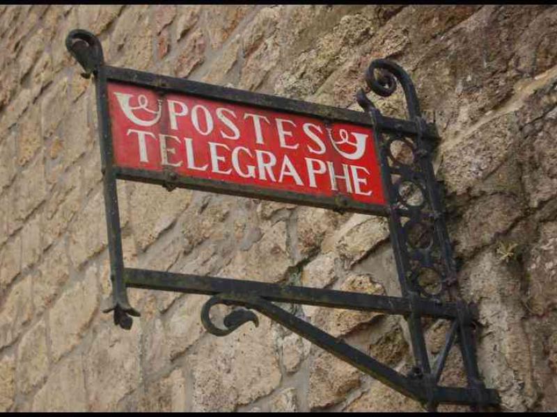 Красная вывеска «Postes Télégraphe» у стен Аббатства Орваль в Бельгии