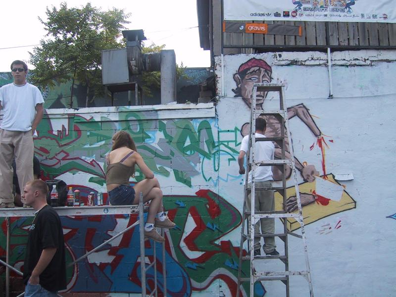 416 Graffiti Expo в Канаде: художник на лестнице и зрители у стены с граффити