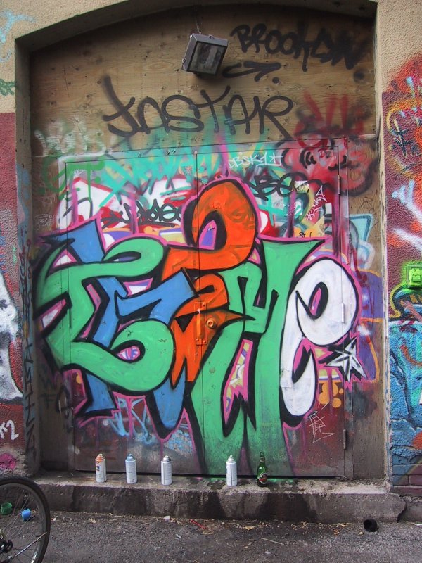 416 Grafitti Expo, Канада: дверь в бетонном арочном проёме, покрытая слоями граффити