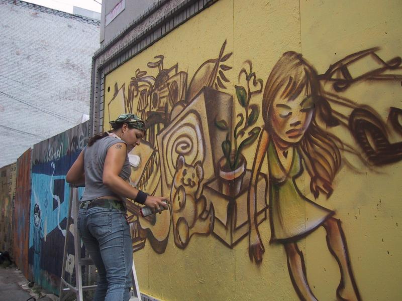 416 Grafitti Expo, Канада: женщина рисует мурал с девочкой и плюшевым медвежонком
