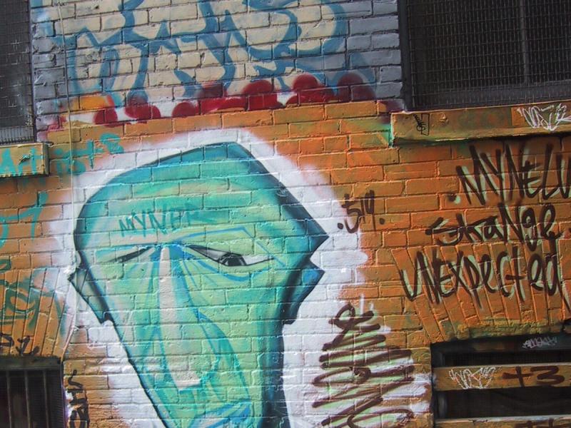 416 Grafitti Expo, Канада: зелёный профиль на кирпичной стене с надписями "MYNER", "UNEXPECTED"