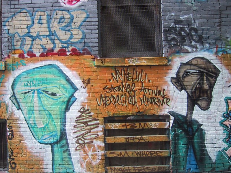 416 Grafitti Expo, Канада: кирпичная стена с граффити и надписями 'Strange Arrival, Unexpected Departure'