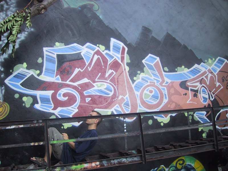 416 Grafitti Expo, Канада: бетонная стена с резким 3D-граффити и человеком у ржавой ограды