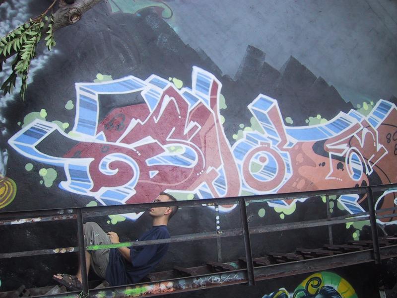 416 Grafitti Expo, Канада: бетонная стена с резким 3D-граффити и человеком у ржавой ограды
