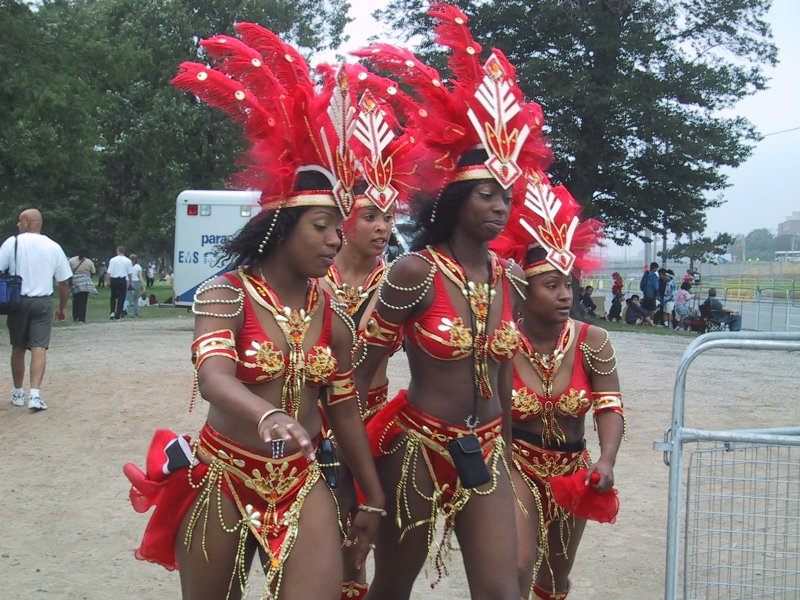 Caribana 2003 в Торонто: танцующие в красно-золотых костюмах с перьями