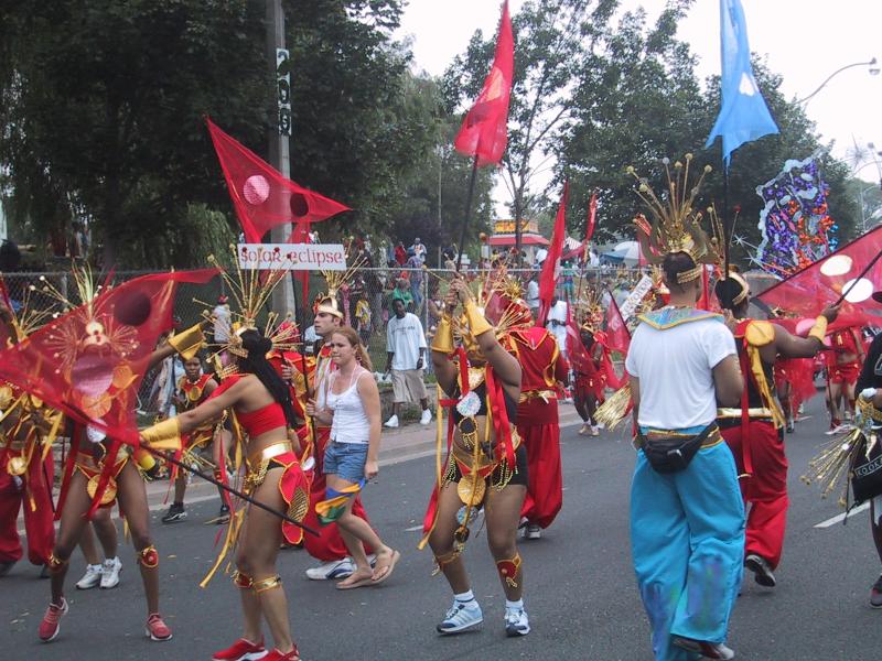 Caribana 2003 в Торонто: красные и золотые костюмы с флагами «solar eclipse»