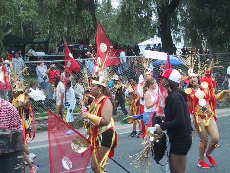 Caribana 2003 в Торонто: красные и золотые костюмы с флагами «солнечного затмения»