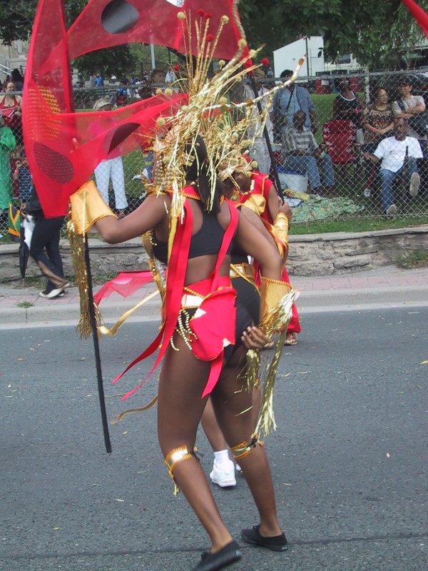 Caribana 2003 в Торонто: танцор в красно-золотом костюме с флагом-лилией
