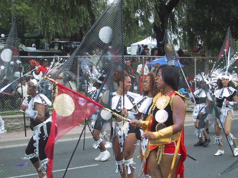 Caribana 2003 в Торонто: танцоры в чёрно-белых костюмах с золотыми акцентами и флагами с кругами