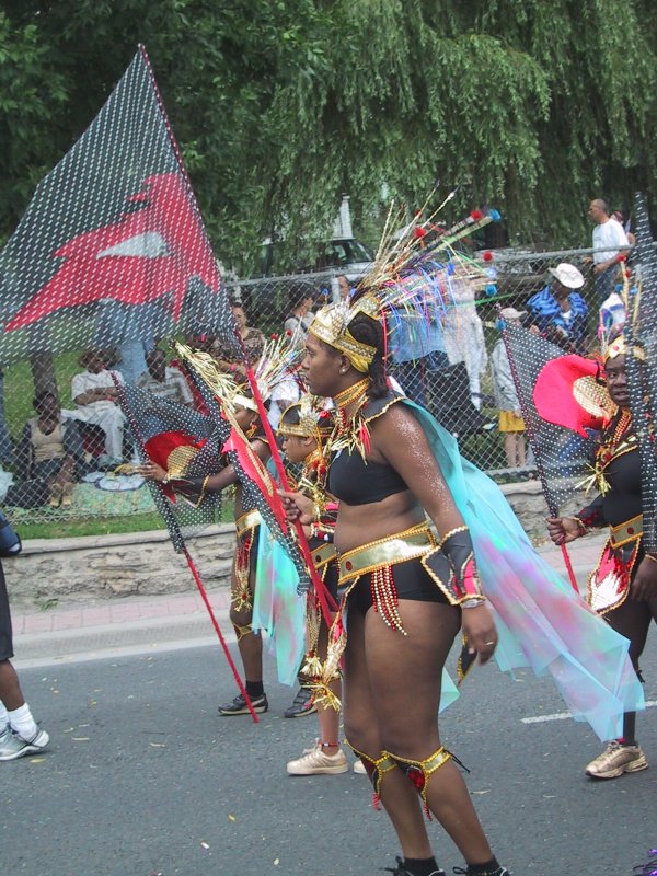 Caribana 2003 в Торонто: танцоры в золотых украшениях и прозрачных плащах на улице