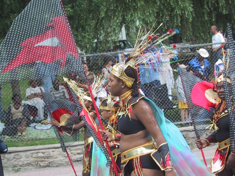 Caribana 2003 в Торонто: танцоры в золотых украшениях и прозрачных плащах на улице