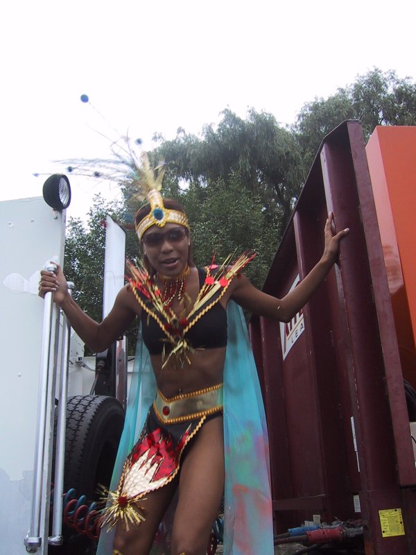 Caribana 2003, Торонто: танцующая участница в индейском костюме с перьями и золотыми украшениями