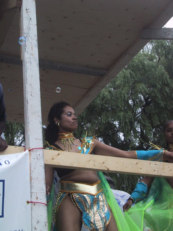 Caribana 2003 в Торонто: танцующая артистка в сине-золотом костюме на плавучем павильоне