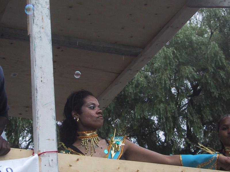 Caribana 2003 в Торонто: танцующая артистка в сине-золотом костюме на плавучем павильоне