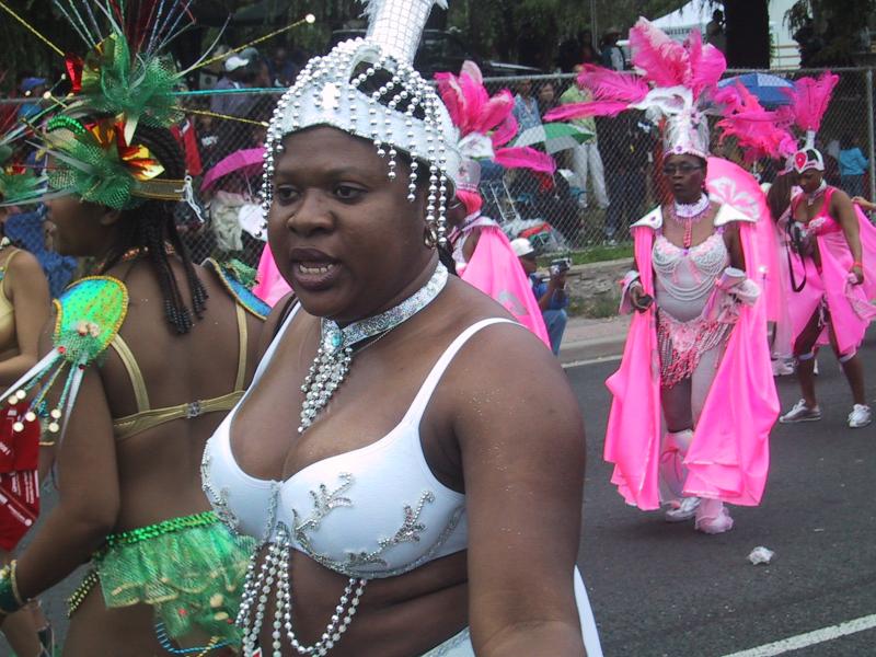 Caribana 2003 в Торонто: белоснежный костюм с жемчужинами и розовые перья на фоне ограждения