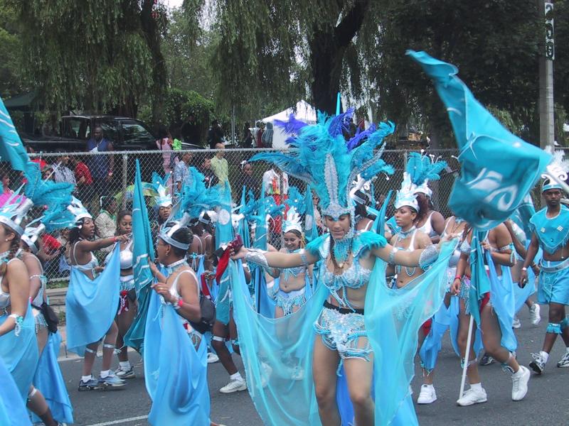 Caribana 2003 в Торонто: танцующие в бирюзовых костюмах с перьями и флагами