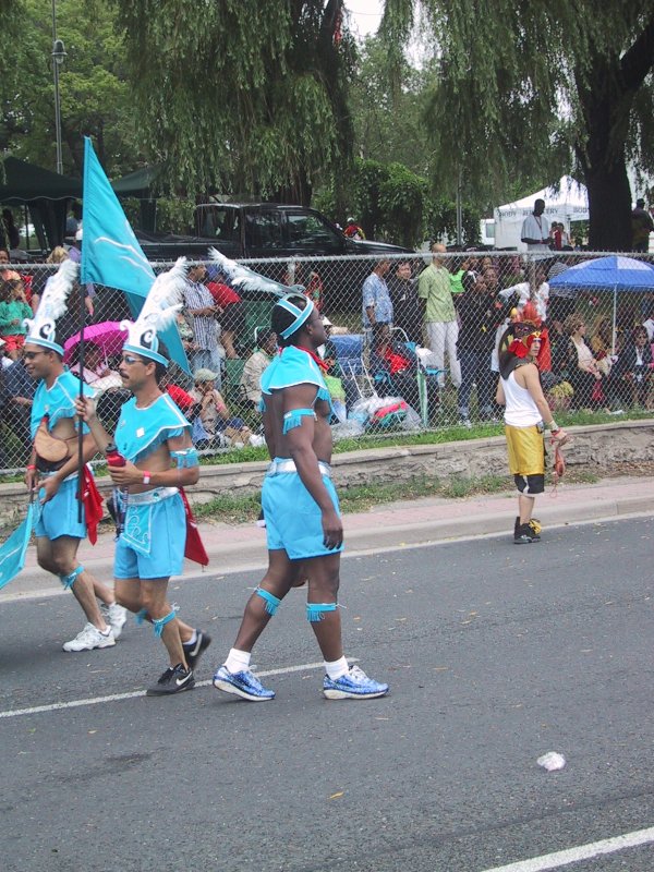 Caribana 2003 в Торонто: танцоры в голубых костюмах с перьями и флагом