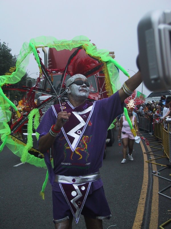 Caribana 2003 в Торонто: танцор в фиолетовом костюме с серебряной краской на лице