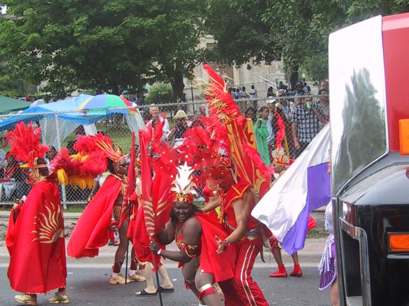 Caribana 2003 в Торонто: красные костюмы с перьями и флагами на улице
