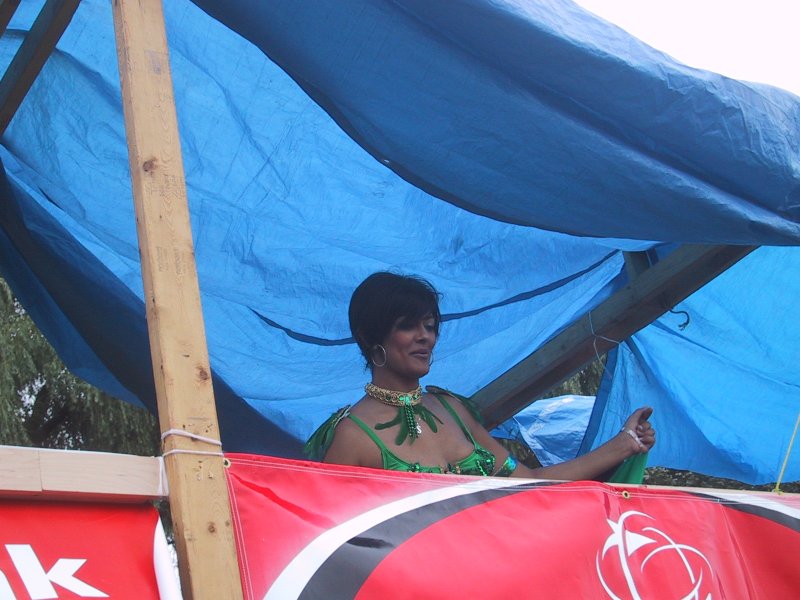 Caribana 2003, Торонто: женщина в зелёном на плавучем декоре под синим тентом