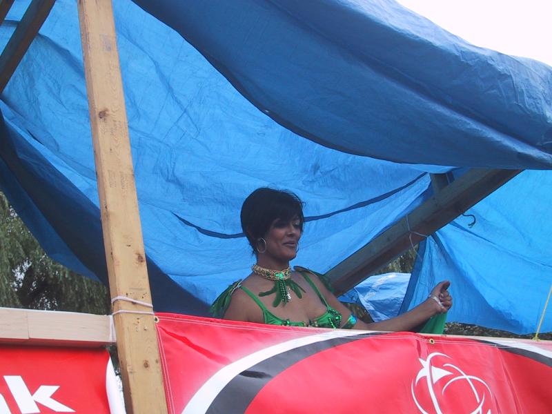 Caribana 2003, Торонто: женщина в зелёном на плавучем декоре под синим тентом