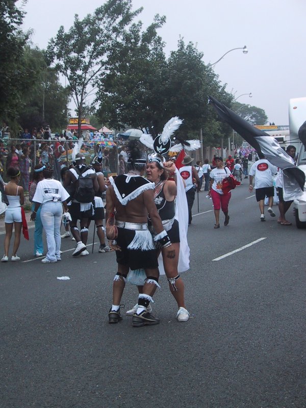Caribana 2003 в Торонто: танцоры в чёрно-белых костюмах с перьями на улице