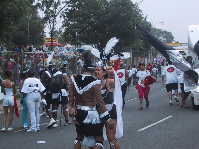 Caribana 2003 в Торонто: танцоры в чёрно-белых костюмах с перьями на улице