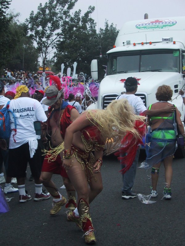 Caribana 2003 в Торонто: красные перья, золотые бусы и белый грузовик Midcontinental Transport Inc.