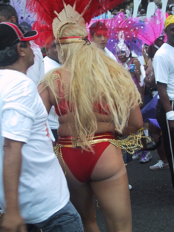 Caribana 2003 в Торонто: золотые цепочки и красные перья на танцующей женщине