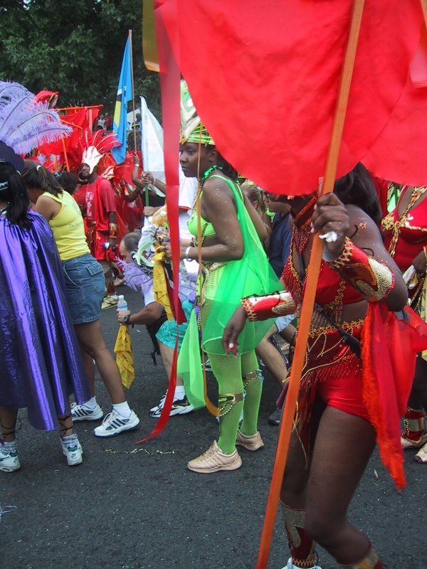 Caribana 2003 в Торонто: зелёная танцовщица с перьями и красным флагом