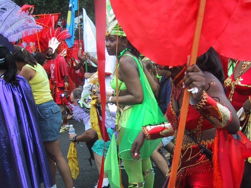 Caribana 2003 в Торонто: зелёная танцовщица с перьями и красным флагом