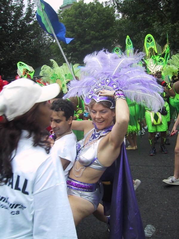 Caribana 2003 в Торонто: фиолетовый костюм с перьями и зелёные костюмы танцоров