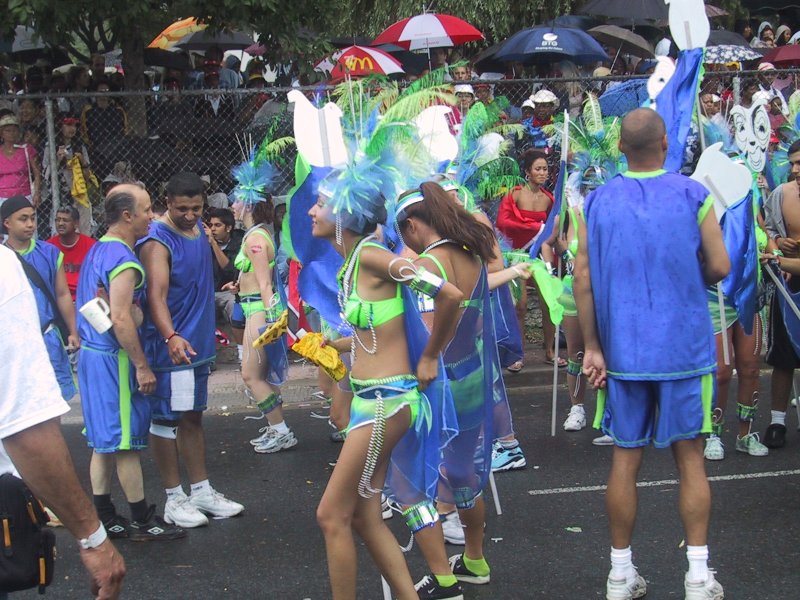 Caribana 2003 в Торонто: сине-зелёные костюмы и зонты над забором