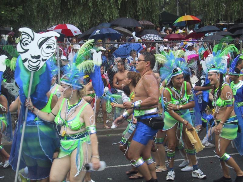 Caribana 2003 в Торонто: зелёно-синие костюмы, маски и дождь за забором