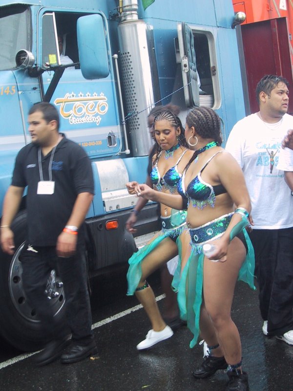 Caribana 2003 в Торонто: танцующие в сине-зелёных костюмах у грузовика Coco Trucking