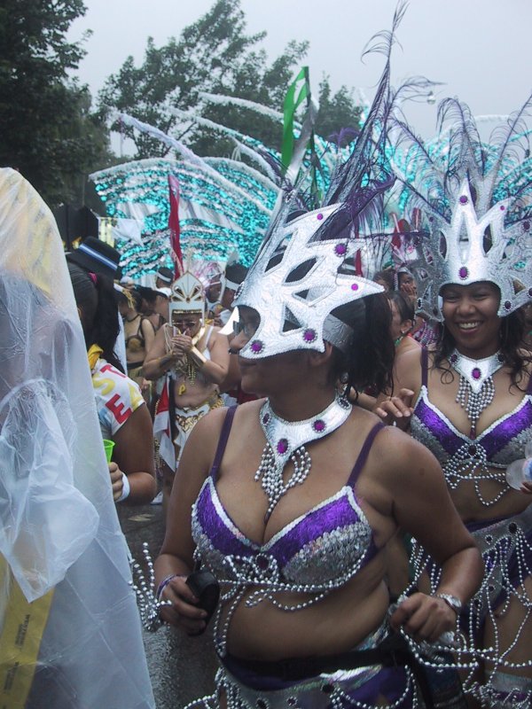 Caribana 2003 в Торонто: танцующие в фиолетово-серебряных костюмах с перьями и масками