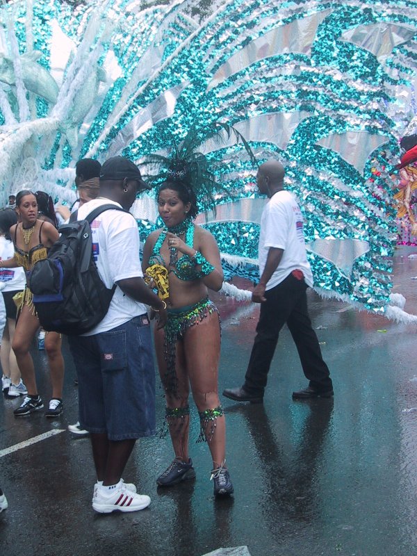 Caribana 2003 в Торонто: блики туркоzового фольгированного костюма на мокром асфальте
