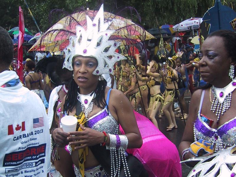 Caribana 2003 в Торонто: женщины в серебряных коронах и фиолетовых костюмах на мокрой улице