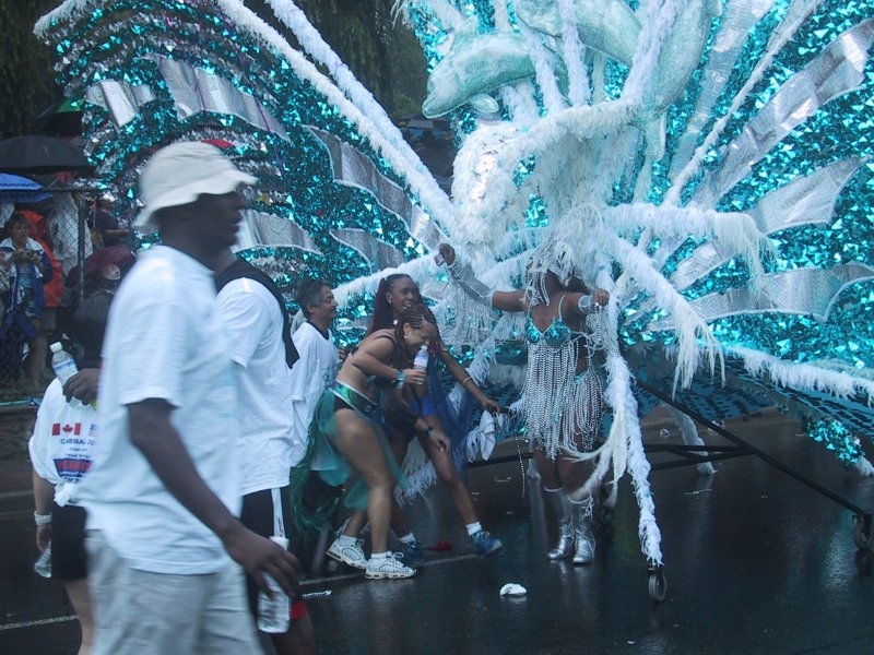 Caribana 2003 в Торонто: бирюзовые дельфины и перья на мокром асфальте