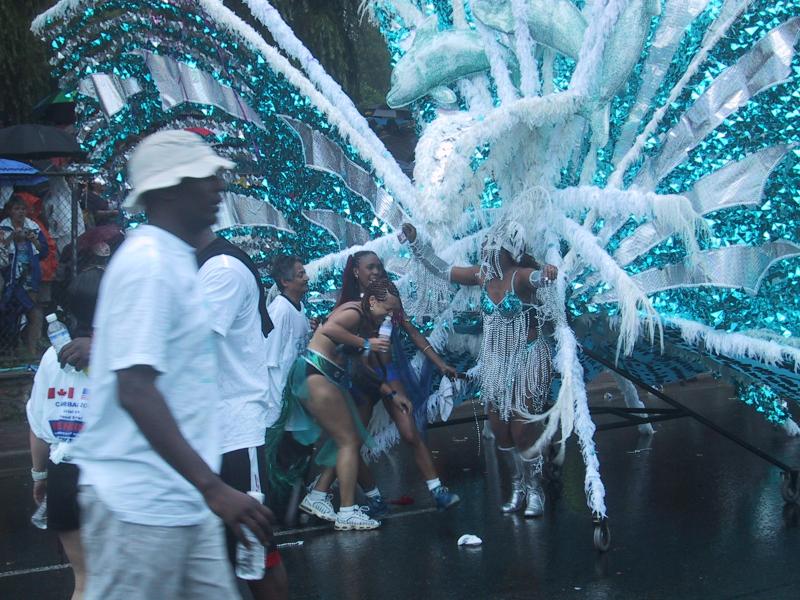 Caribana 2003 в Торонто: бирюзовые дельфины и перья на мокром асфальте