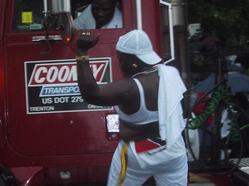 Caribana 2003, Торонто: женщина в белом на борту красного грузовика Coomy Transport