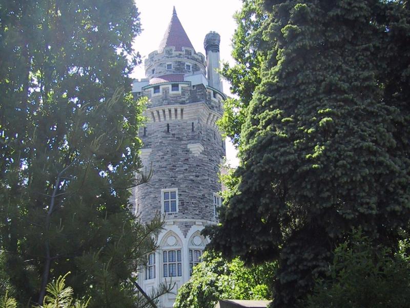 Касса-Лома: башня из серого камня с красной шатровой крышей между елями