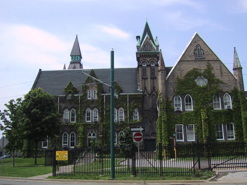 Старинное здание в Green Toronto, покрытое плющом и с башнями в готическом стиле