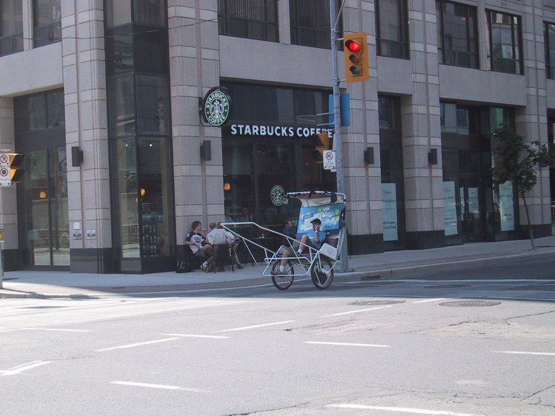 Канадский угловой Starbucks с рикшей у перекрёстка