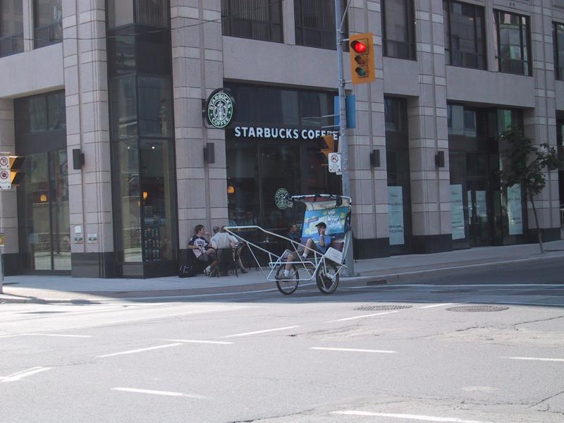 Канадский угловой Starbucks с рикшей у перекрёстка