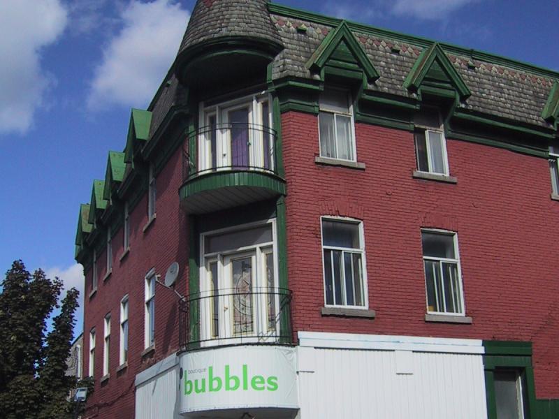 Монреаль, 2004: красно-зелёный дом на углу с балконом и вывеской «boutique bubbles»