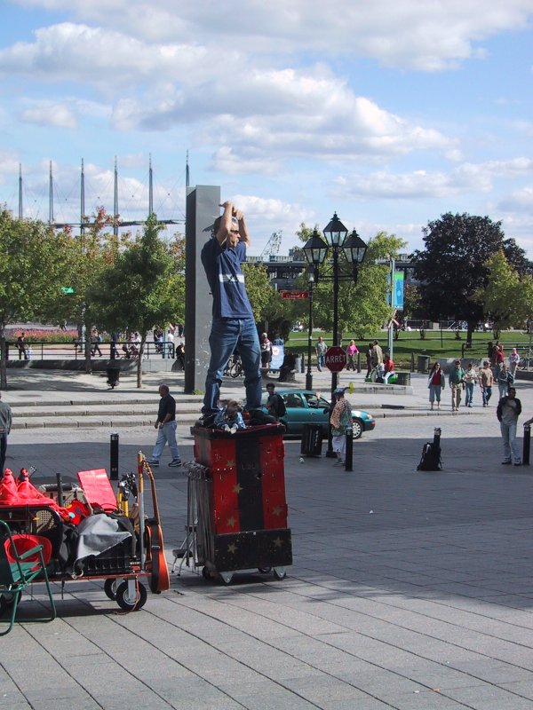 Монреаль, 2004: уличный артист на красной платформе у моста с тремя мачтами